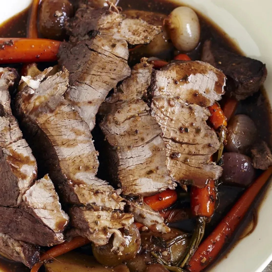 sliced slow roast beef in slow cooker with vegetables
