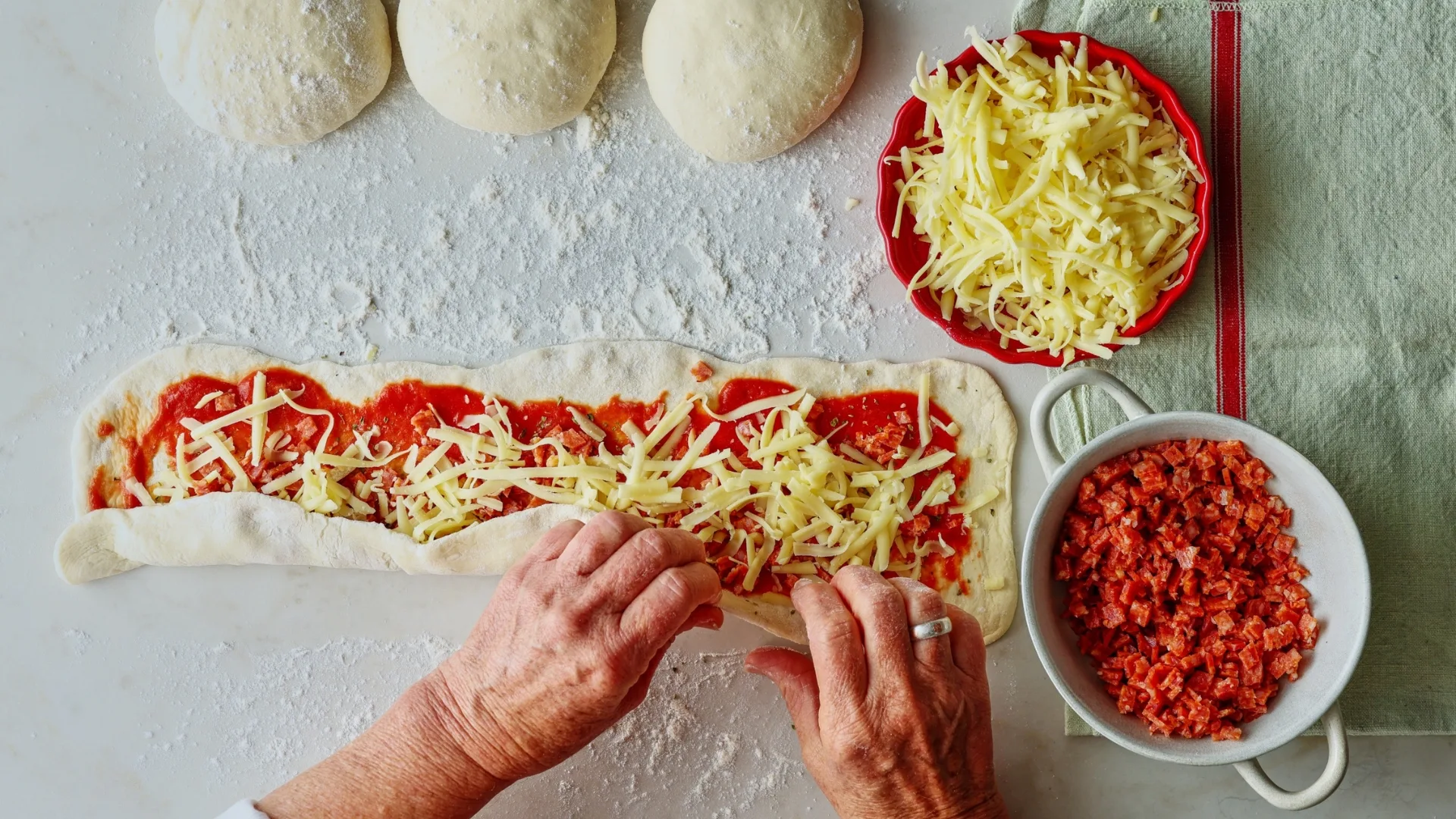 rolling savoury scroll dough into a log