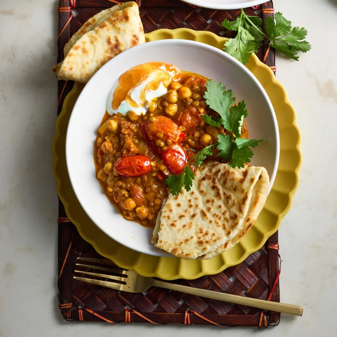 Vegetarian curry, chickpea and lentil, in a bowl with naan