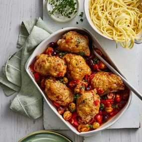 air fryer chicken cacciatore recipe in a white dish with a spoon, and a bowl of pasta