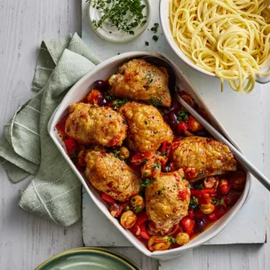 air fryer chicken cacciatore recipe in a white dish with a spoon, and a bowl of pasta