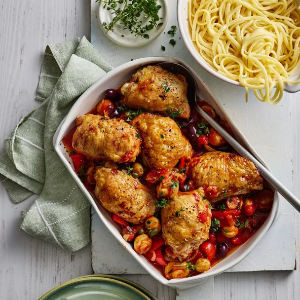 air fryer chicken cacciatore recipe in a white dish with a spoon, and a bowl of pasta