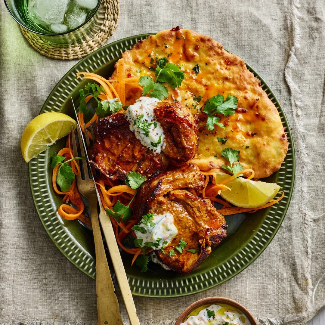 air fryer tandoori lamb chops with flatbread and lemon wedges on a plate