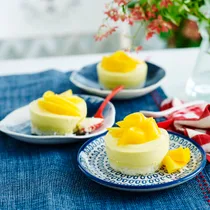 Three mini mango cheesecakes on plates