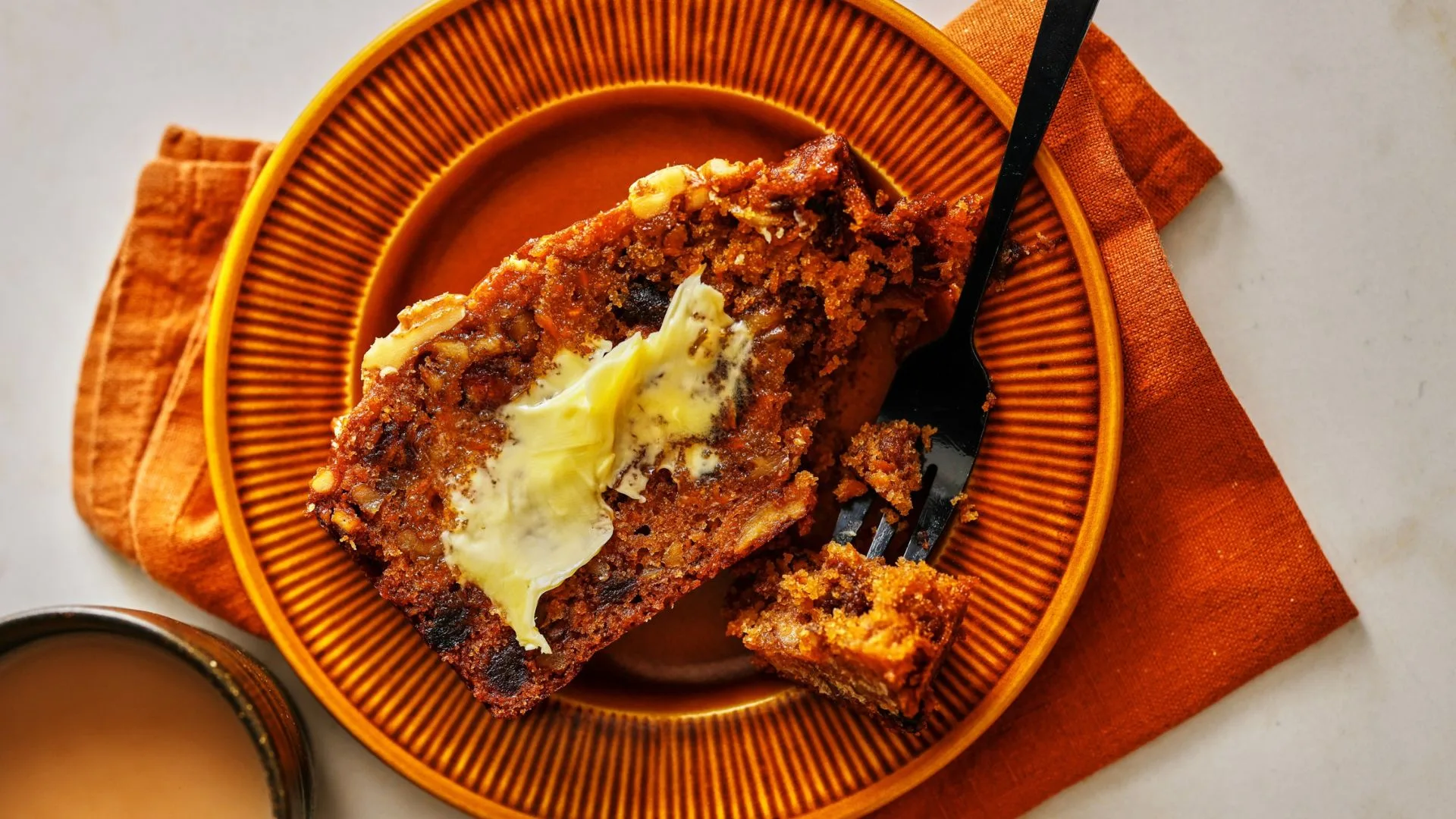 slice of carrot and date cake with butter