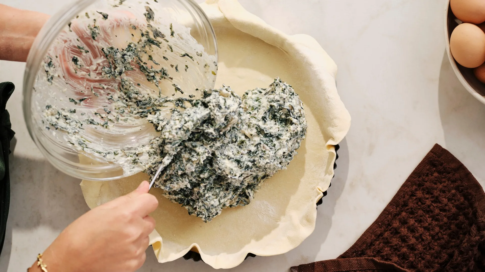 laura sharrad tipping silverbeet and ricotta pir filling into tart shell
