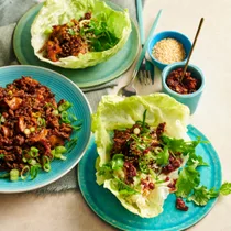 two lettuce cups with san choy bow beef, and a third plate with beef mixture