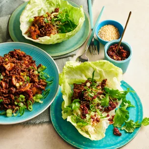 two lettuce cups with san choy bow beef, and a third plate with beef mixture