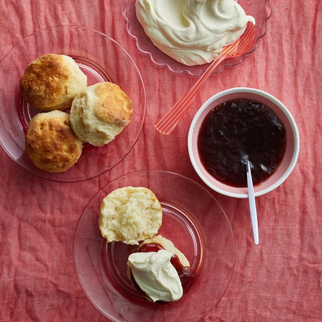 small batch scones with jam and cream on a pink tablecloth