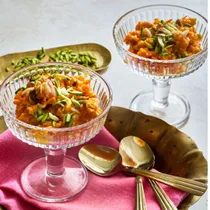 Carrot Halwa in two serving glasses, topped with chopped pistachios