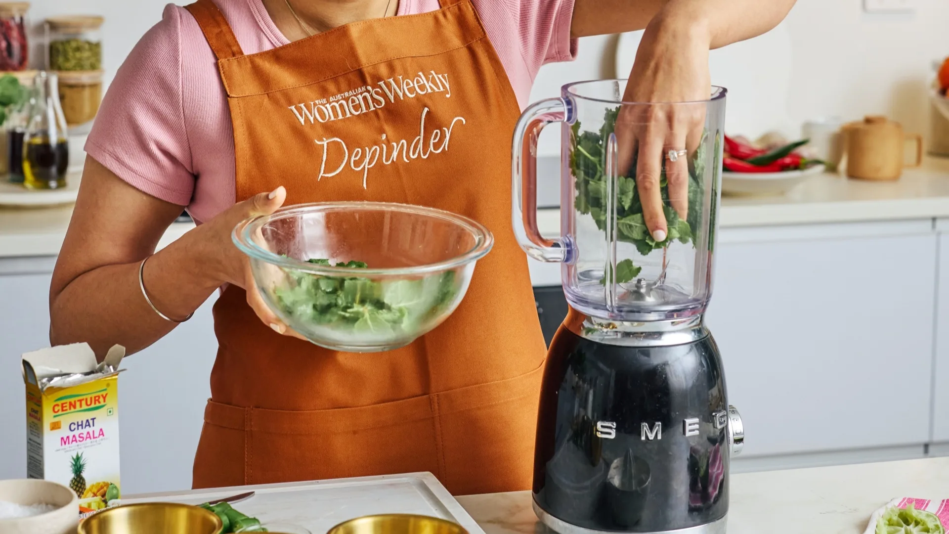 depinder chhibber placing herbs into a blender