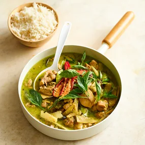 Bowl of Thai green chicken curry in a white pan