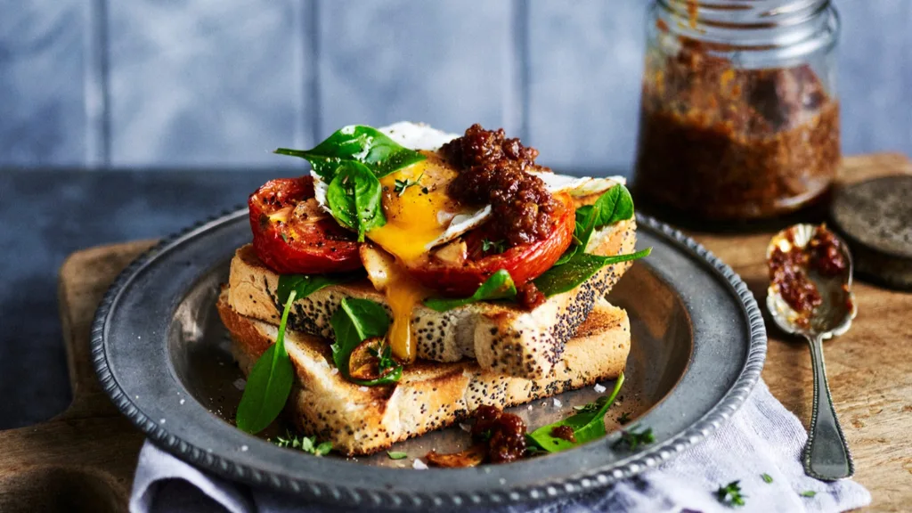 bacon jam on top of toast with tomato, egg and spinach