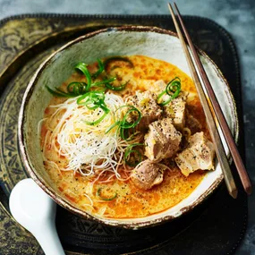 bowl of slow cooker pork laksa with chopsticks and a spoon