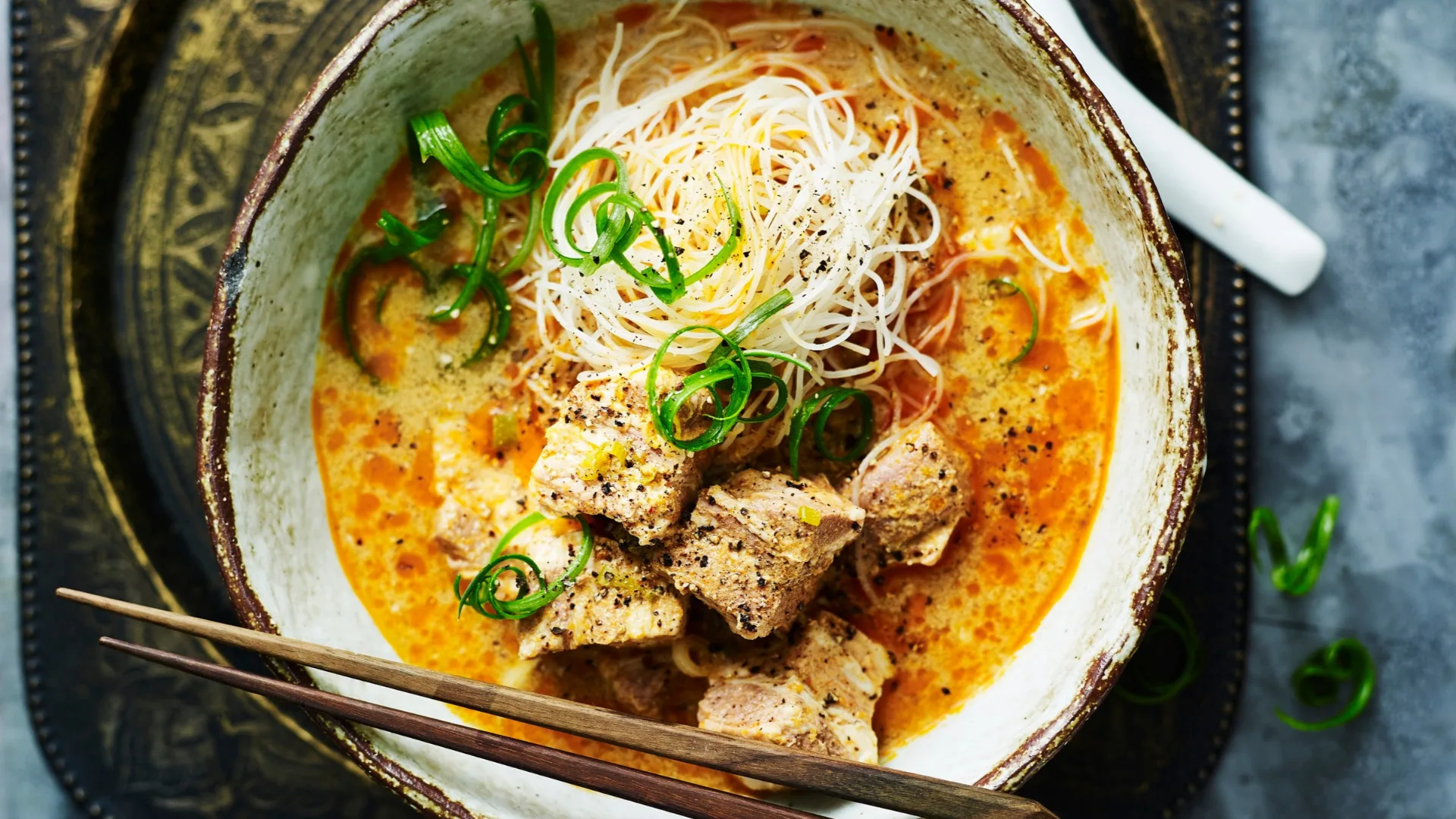 bowl of slow cooker laksa topped with green onion