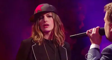 Anne Hathaway wears a cap with a red star, performing in a rap battle on The Late Late Show with James Corden.