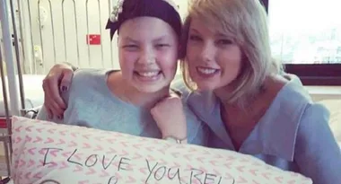 ```html
<img src="image-url.jpg" alt="Woman with hospital patient, holding pillow with 'I love you.' message, smiling together." />
```