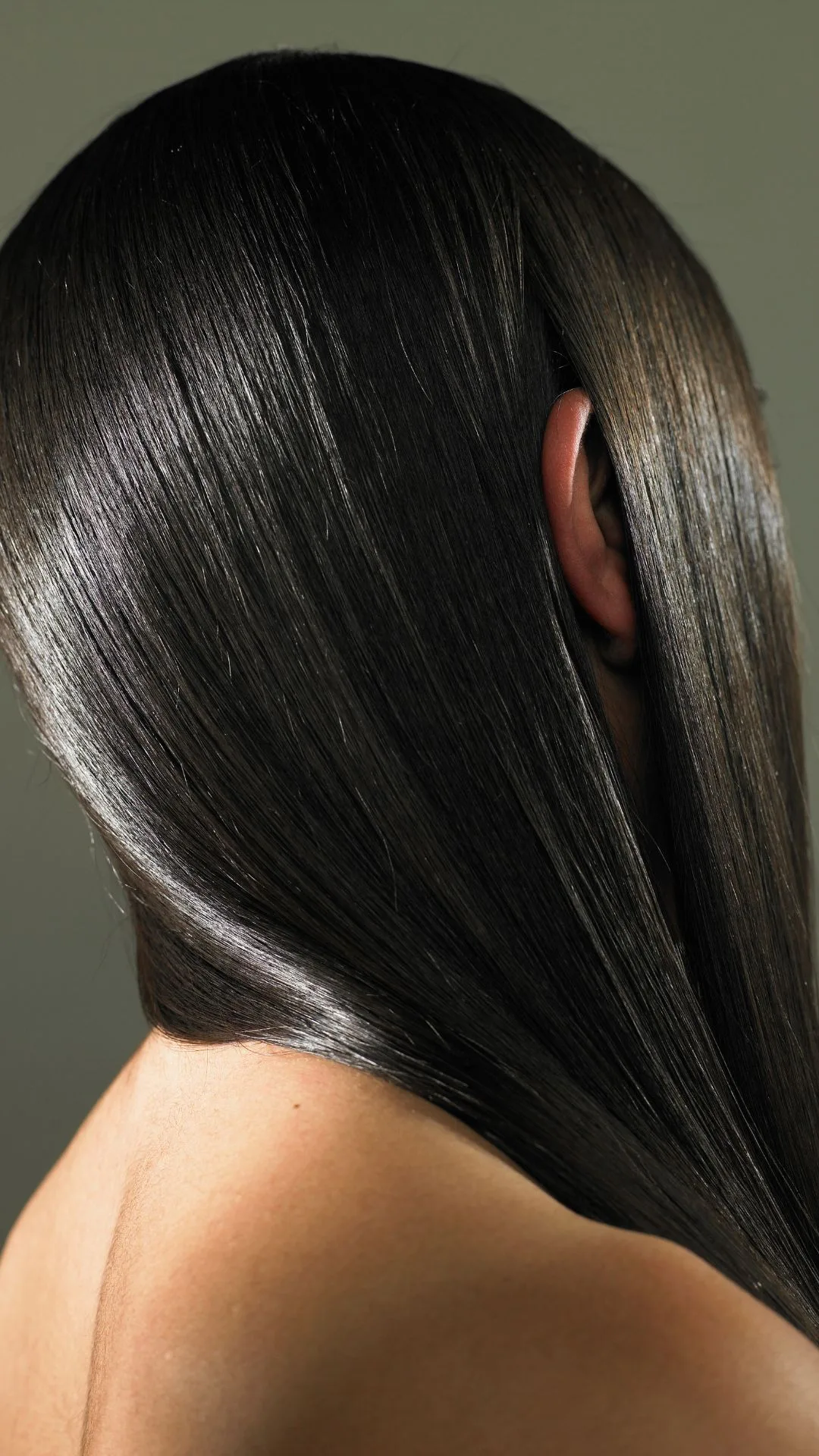 Young woman with ear sticking out of long hair, side view - stock photo