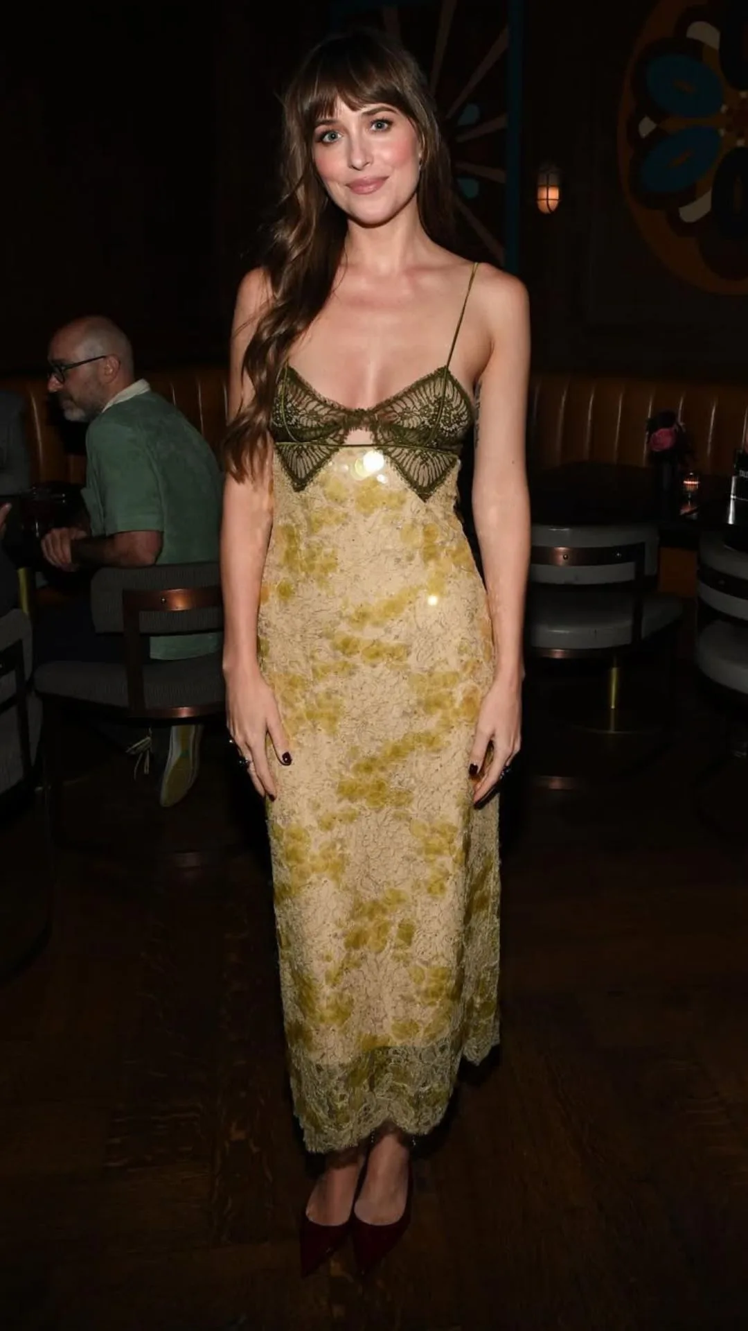 Woman wearing yellow silk gown smiling.