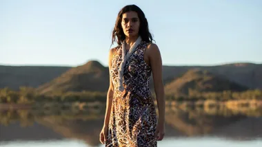 Madeleine Madden standing in front of a desert landscape with lake