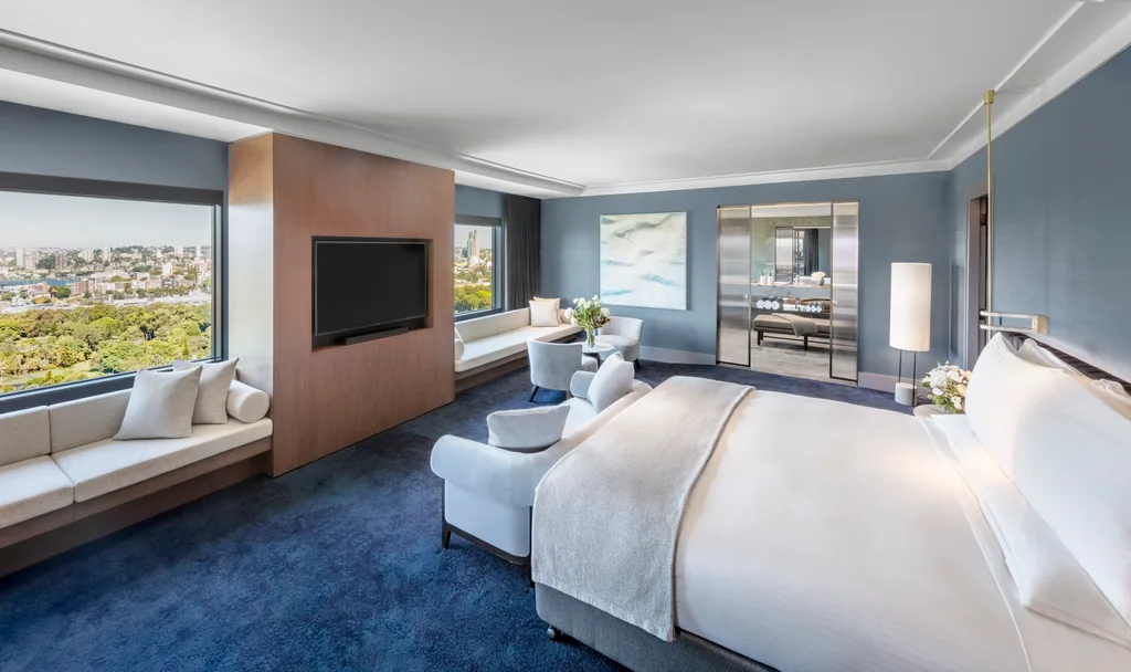 A photo showing the Presidential Opera Suite in Sydney's InterContinental hotel. A bedroom with blue carpet and blue walls overlooks Sydney's Hyde Park.