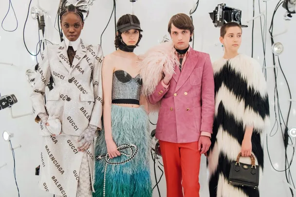 Models in Gucci-Balenciaga outfits pose amid studio lighting and equipment.