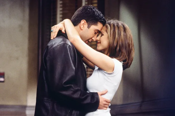 A couple lovingly embraces, foreheads touching, in a warm, intimate moment.