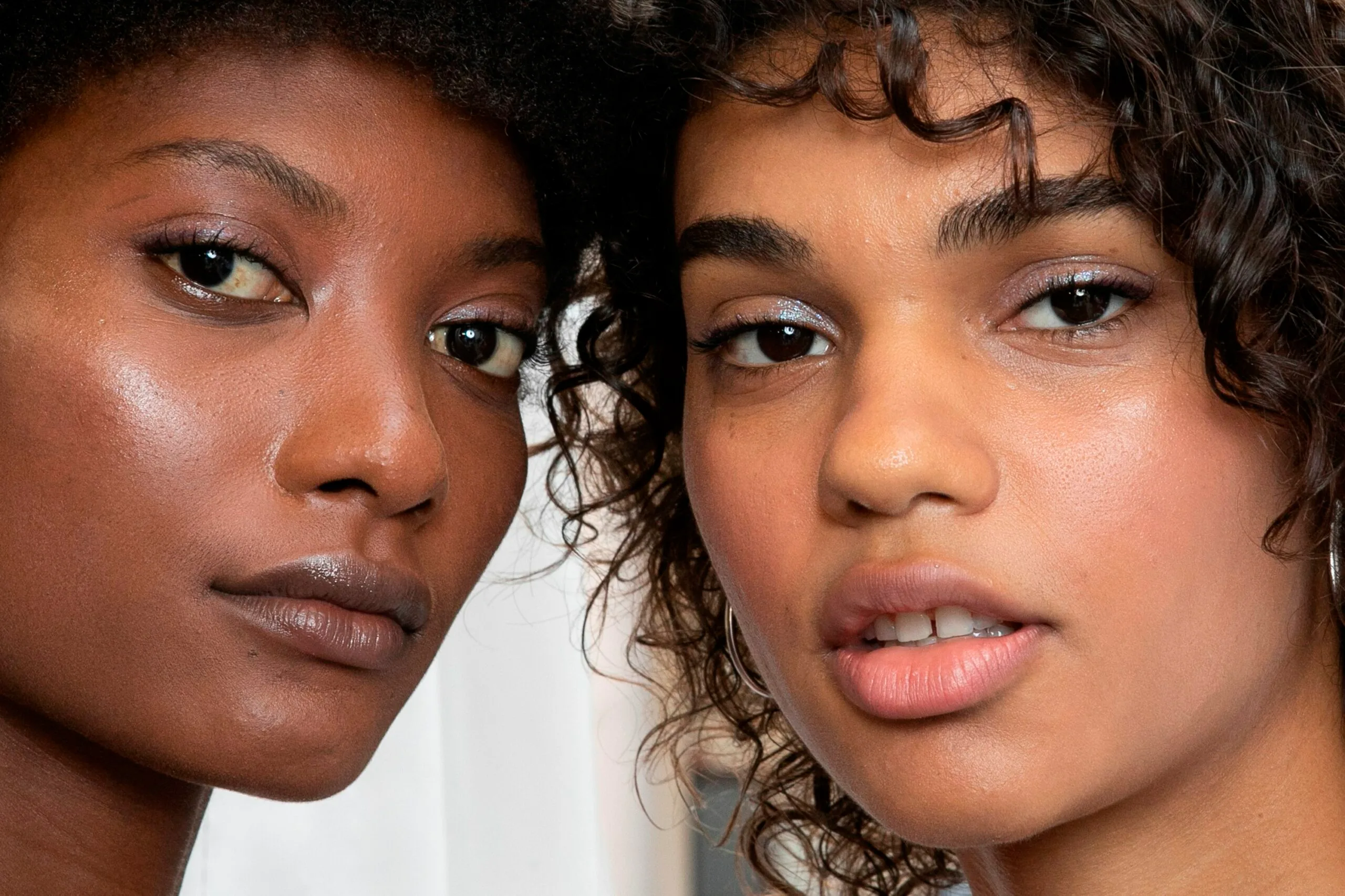 Two women with close-up on their faces, showcasing smooth skin and natural makeup.
