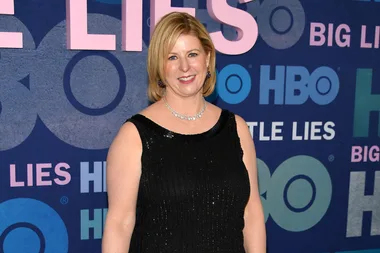 Woman in a black dress smiling at the "Big Little Lies" HBO event backdrop.