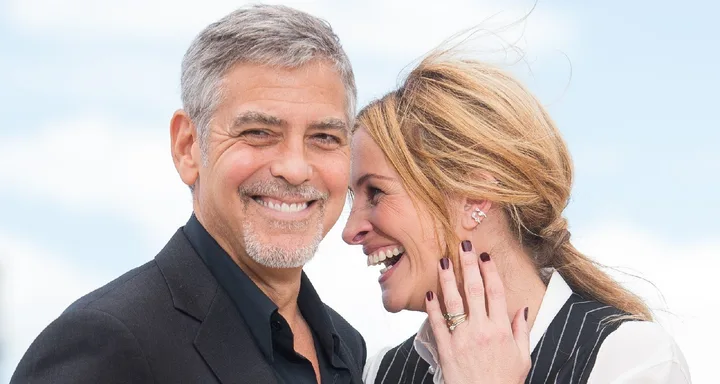I don't know who these people are, but they are smiling and standing close together, outdoors.