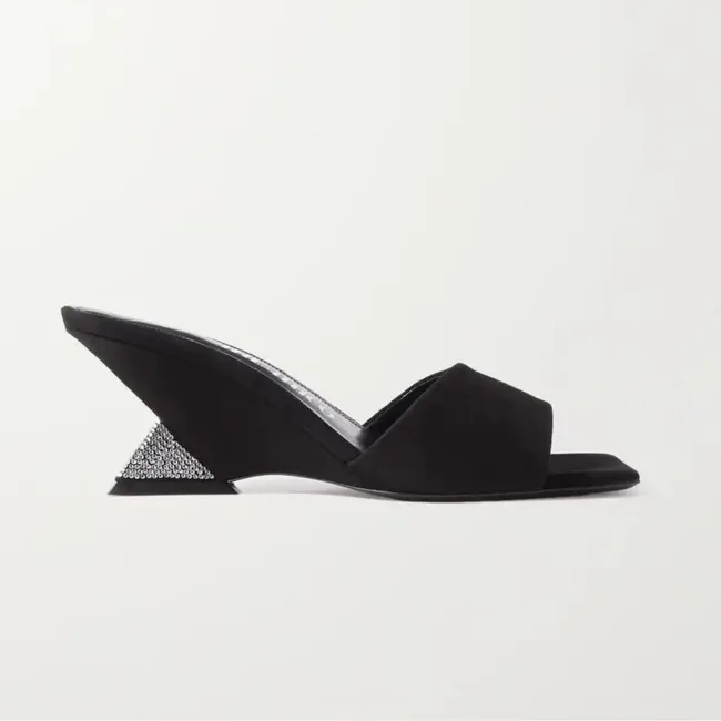 Black wedge sandal with open toe and rhinestone-studded triangular heel against a white background.