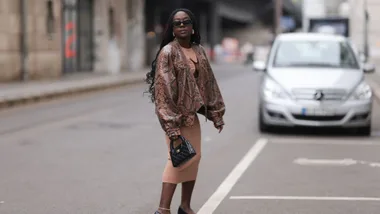 woman crossing the road in a snakeprint jacket