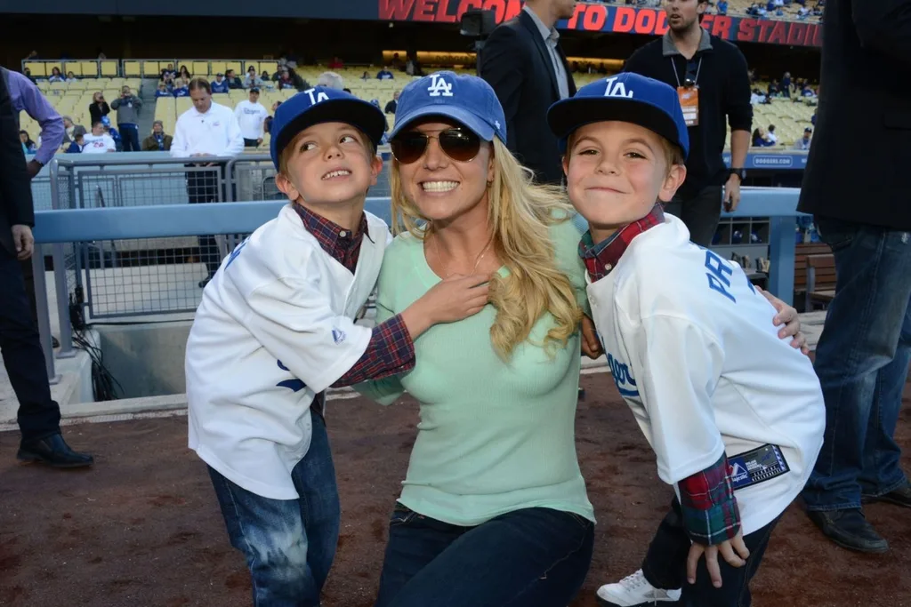 A blonde woman smiling with two young boys either side of her.
