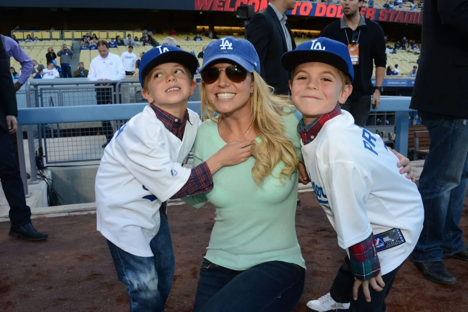 A blonde woman smiling with two young boys either side of her. 