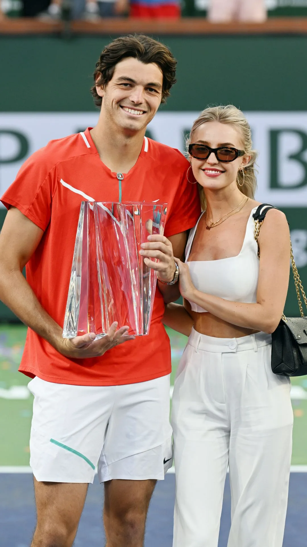 Taylor Fritz of the United States holds the championship trophy with girlfriend Morgan Riddle after winning a finals tennis match at the BNP Paribas Open played on March 20, 2022