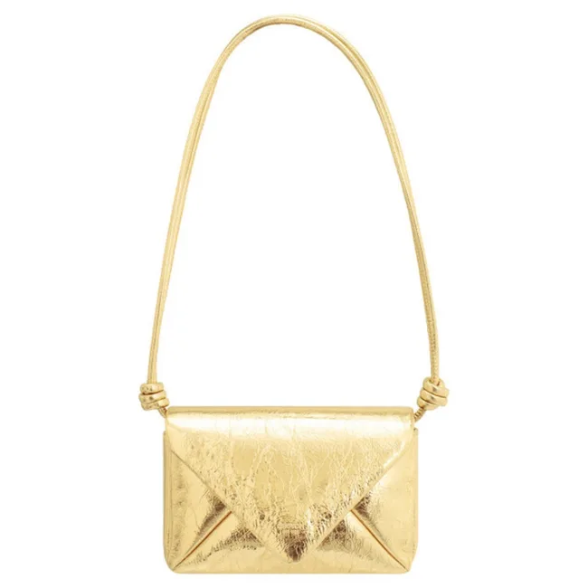 A shiny gold envelope-style purse with a thin shoulder strap.