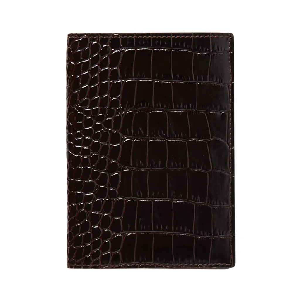 Smythson Mara Croc-Effect Leather Passport Cover is deep brown with calf leather and a tactile croc effect finish. With a high gloss the cover features separate compartments for passport and boarding pass.