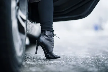 high heeled booted foot getting out of a car