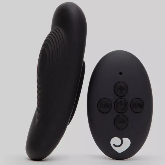 Remote control and black silicone device, featuring textured and smooth surfaces on a gray background.