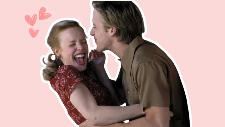 A woman laughing as a man playfully pretends to kiss her cheek against a pink background with heart doodles.