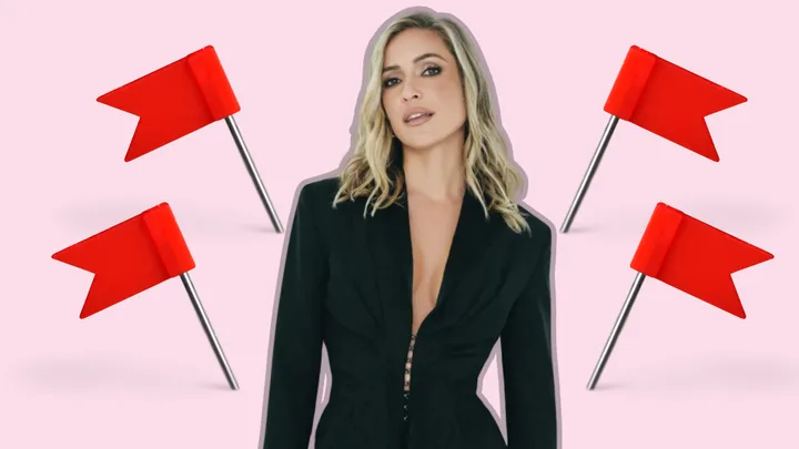 A woman in a black outfit stands surrounded by four red flags on a light pink background.