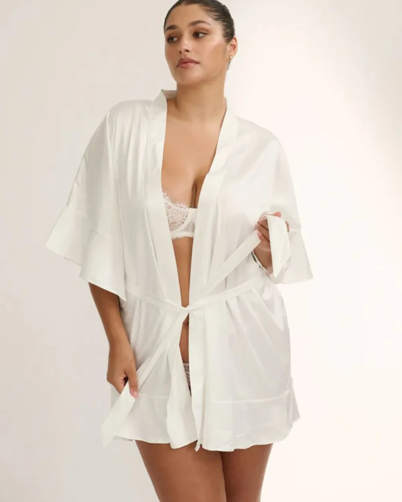 A woman wearing a short white silk robe.