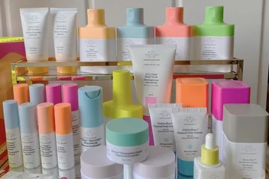 Collection of Drunk Elephant skincare products on a shelf, featuring cleansers, moisturizers, and serums in colorful packaging.