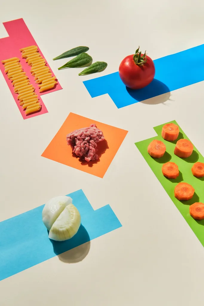 raw ingredients on yellow background to make macaroni bolognese recipe