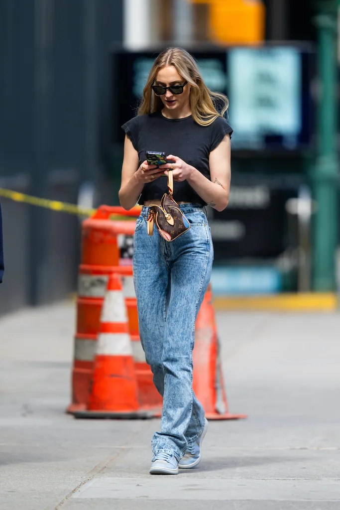 Sophie Turner wearing acid wash style jeans in New York in late 2023.