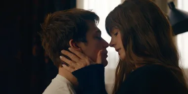 Young couple embracing closely, touching foreheads with a tender expression.