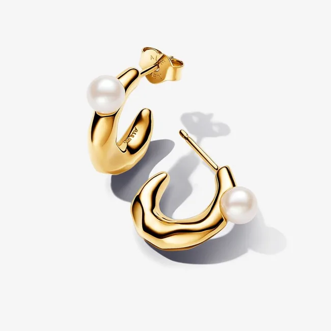 Gold hoop earrings with pearls on a white background.