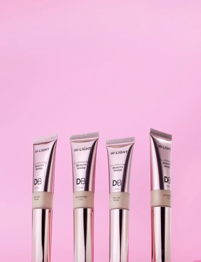 beauty highlighter wands on a pink background