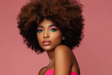 beautiful afro woman with bright makeup on pink background