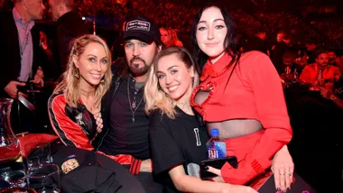 Half the Cyrus famile - Tish, Billy Ray, Miley and Noah Cyrus - agsinst a red background in 2017